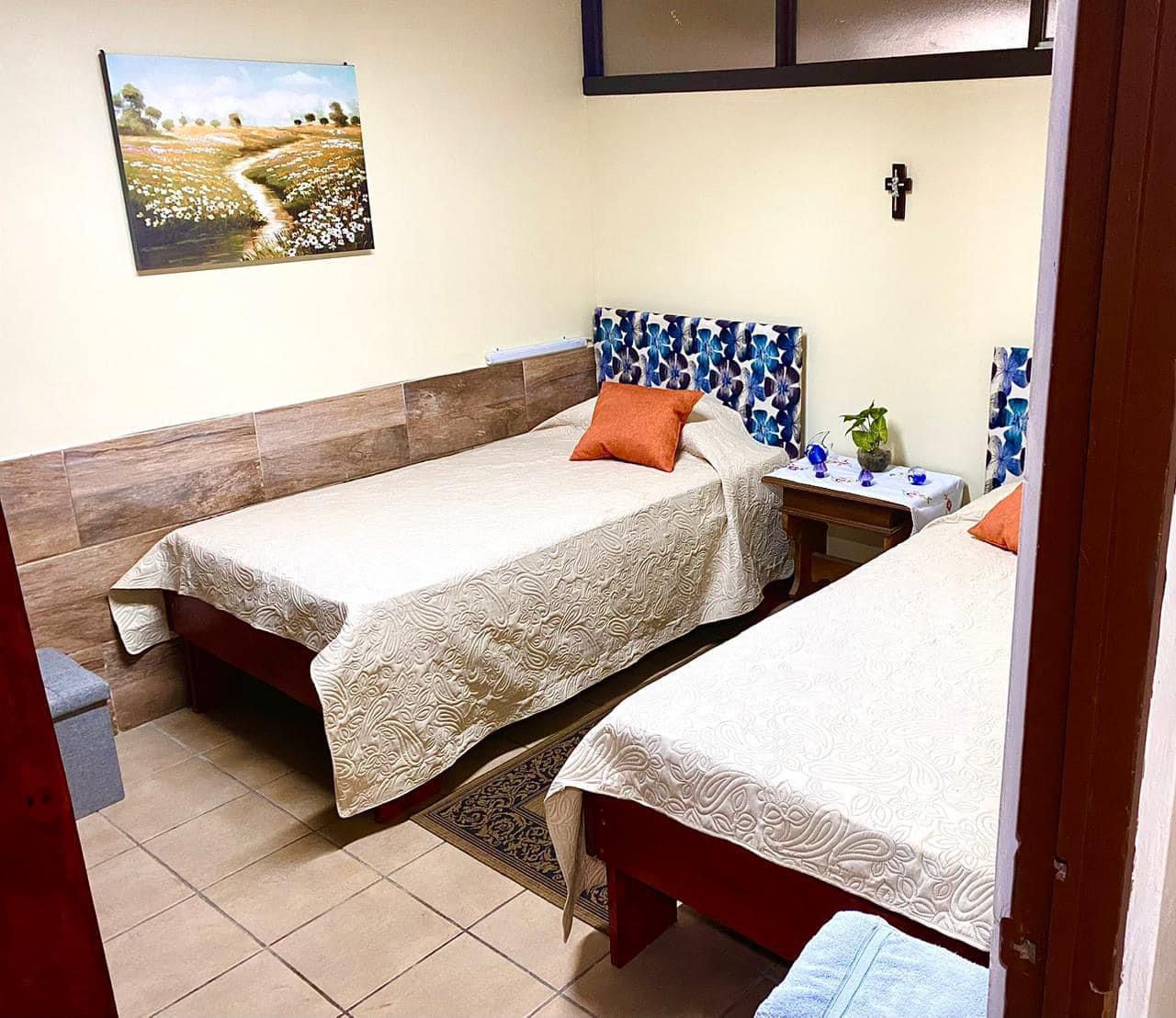 Cuarto con dos camas individuales y mesa de noche en MiniHaus